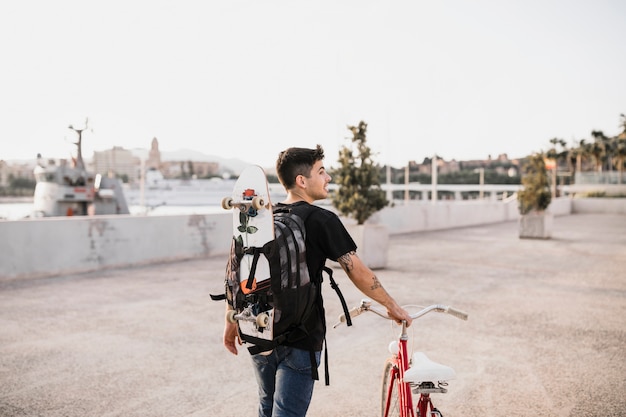 Young Man Riding Bicycle with Skateboard â Free Download