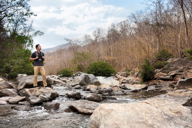 Hiker on Stone Gazing Upwards – Free Download