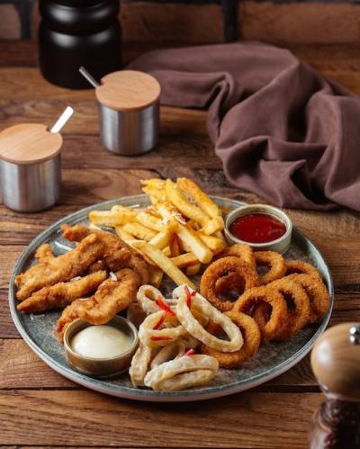 Delicious French Fries, Fried Chicken Wings, and Onion Rings on a Wooden Table – Free Download