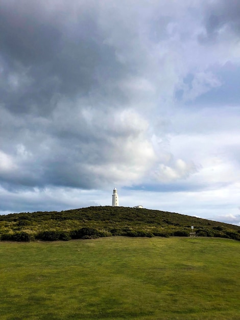 Lighthouse on Field Against Sky – Free Stock Photo for Download