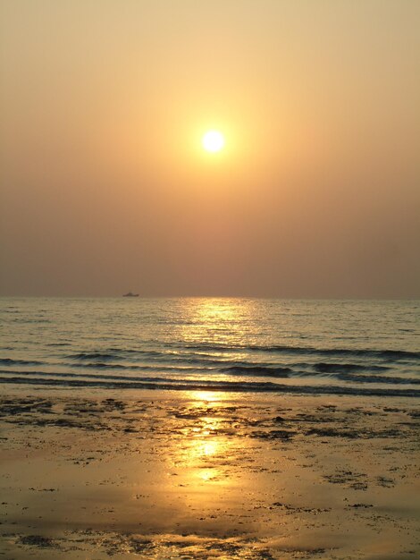 A Beautiful Sunset Over a Beach with a Boat – Free Stock Photo for Download