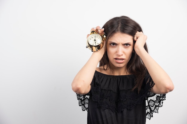 Young Woman Holding Her Head with Clock – Free Stock Photo for Download