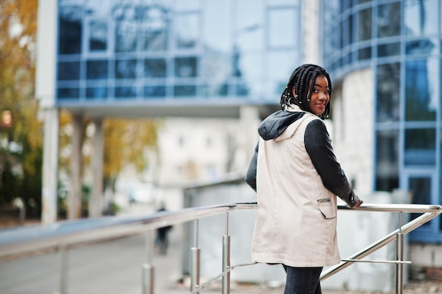 Attractive African American Woman in Jacket Posing by Modern Multistory Building – Free Download