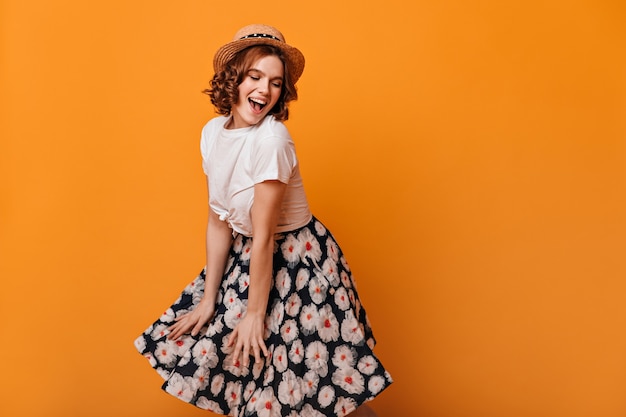 Charming European Lady in Skirt Dancing Against a Yellow Background – Free Download