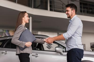 Lateral View of a Young Man Shaking Hands with a Car Dealer – Free Download