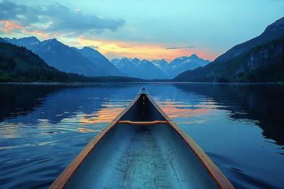 A Canoe on the Serene Waters of M Wanic Lake, Canada â Majestic Mountains and Clear Blue Sky Reflections | Free Download