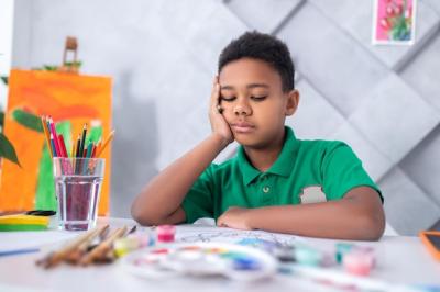 Thoughtful Boy at Table with His Drawing – Free Download