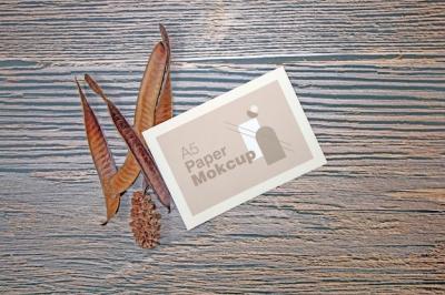 A5 Paper Greeting Card Mockup Featuring Dry Leaves on Wooden Background – Free Download