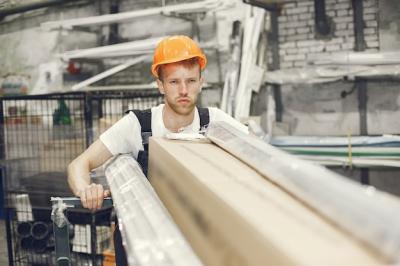 Young Technician in an Orange Hard Hat at an Indoor Factory – Free Stock Photo for Download