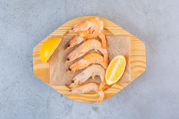 Delicious Shrimps in a Wooden Bowl with Sliced Lemon on Stone Surface – Free Download