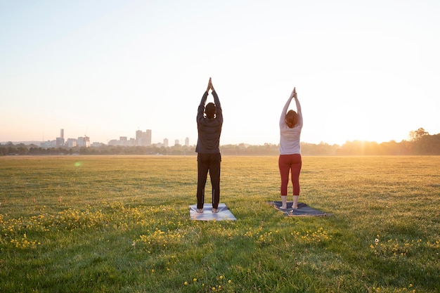 Back View of Man and Woman Practicing Yoga Outdoors – Free Download