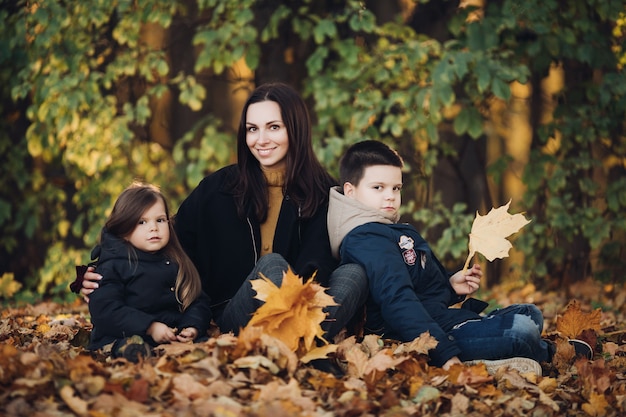 Mum with Long Black Hair and Children Holding Bouquets of Autumn Leaves – Free Stock Photo for Download