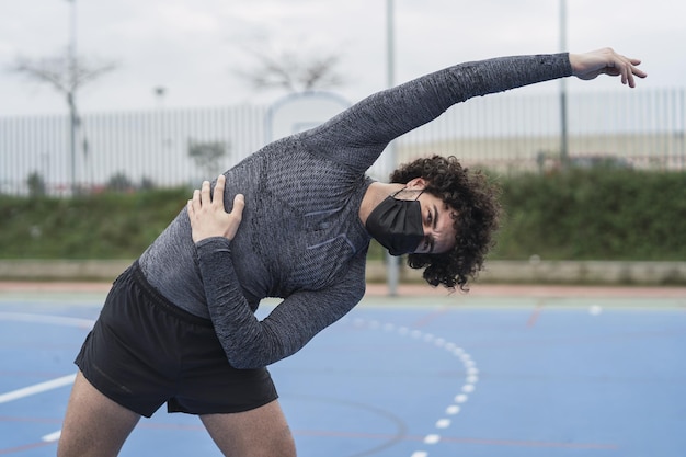 Young Spanish Male in a Black Mask Stretching – Free to Download