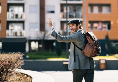 Businessman Walking with Arm Raised in Greeting – Free Stock Photo for Download