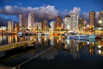 Skyscrapers illuminated by evening lights over the river – download free stock photo