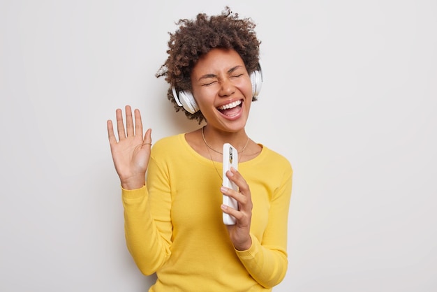 Millennial Girl Enjoying Music with Curly Hair and Smartphone – Free Download