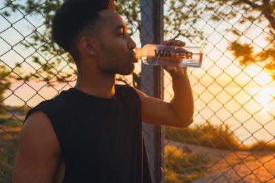 Young Man Drinking Water on Basketball Court at Sunrise – Free Stock Photo