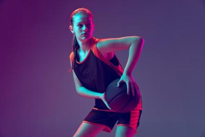 Young Girl Basketball Athlete Training Against Neon Purple Background – Free Download