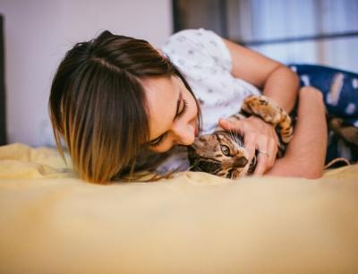 Playful Moments: Woman and Bengal Cat on Bed – Free Download