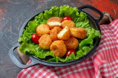 Delicious Chicken Nuggets with Lettuce and Cherry Tomatoes on Dark Red Background – Free Download