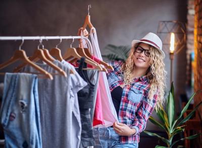 Positive Blonde Female in Black Eyeglasses Choosing Fashionable Clothes – Free Stock Photo for Download