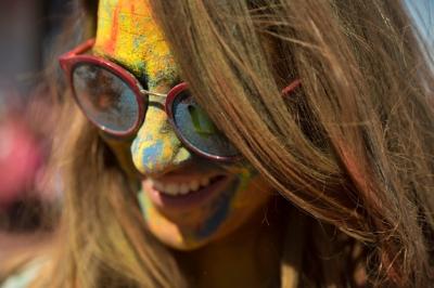 Close-Up of a Woman’s Face Drenched in Holi Colors with Eyeglasses – Free Download