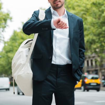 Close-Up of a Businessman with White Backpack Checking Time on the Street – Free Download