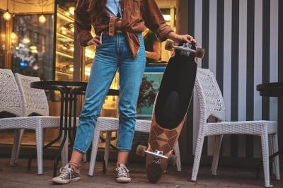 Trendy Hipster Woman Posing with Longboard Near Cafe – Free Download