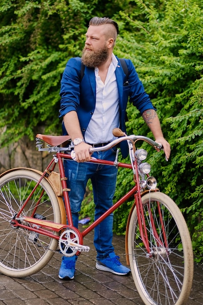 Redhead Bearded Male in a Blue Jacket Riding a Retro Bicycle in the Park – Free Download