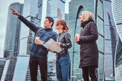 Handsome Man Guiding Female Tourists in Front of Moscow’s Skyscrapers – Free Stock Photo for Download