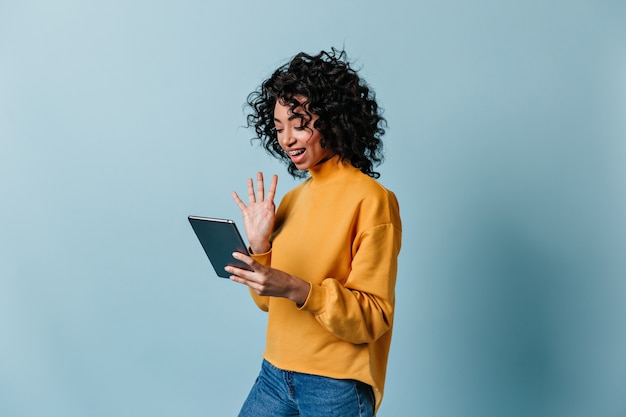 Smiling Woman Waving at Digital Tablet Screen – Free Download