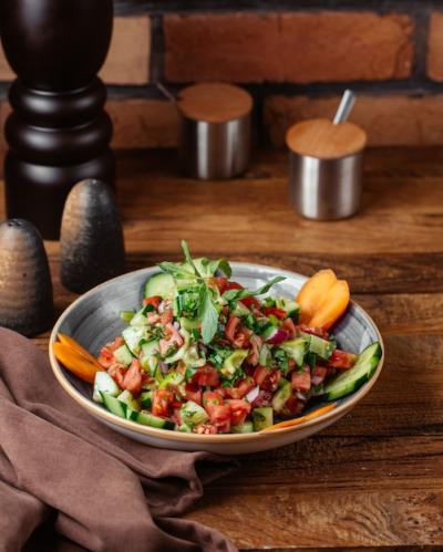 Front View of a Vegetable Salad with Lemon on a Brown Wooden Table – Free Stock Photo for Download