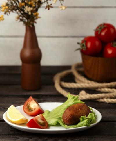 Chicken Kiev with Lemon and Tomato on Wooden Table – Free Stock Photo for Download