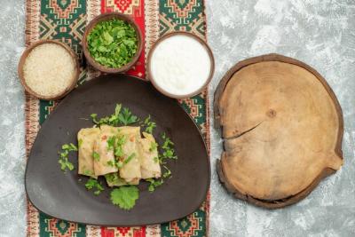 Close-up of Stuffed Cabbage Rice on Grey Plate with Herbs and Sour Cream – Free Download