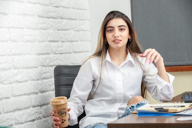 Young Beautiful Girl Sitting Behind Desk with Coffee Cup – Free Stock Photo for Download