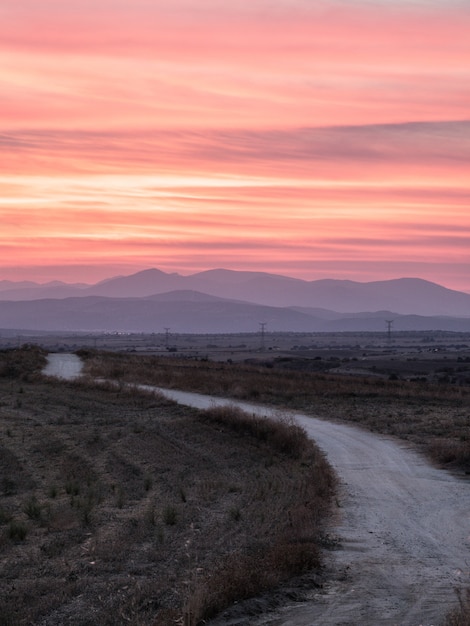 Pathway in a Grassy Field Beneath a Breathtaking Sunset – Free Download