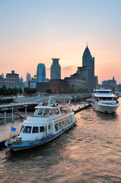 Boat in Huangpu River Against Shanghai Skyline at Sunset – Free Download