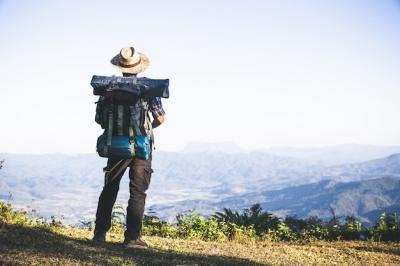 Stunning Mountain Top Tourist with Sun Rays and Backpack – Free to Download