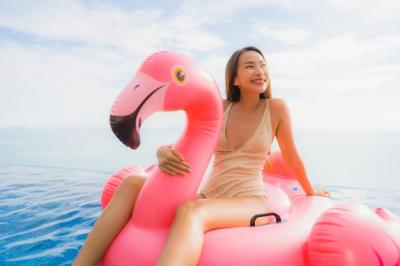 Young Asian Woman on Inflatable Flamingo Float in Hotel Resort Swimming Pool – Free to Download