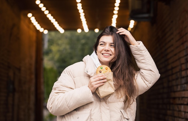 Attractive Young Woman Enjoying Gingerbread with Bokeh Background – Free Stock Photo, Download for Free