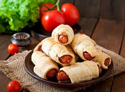 Sausage in Dough Sprinkled with Sesame Seeds on Rustic Wooden Background – Free Download