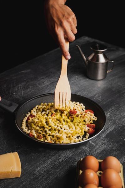 Close-up of a Person Mixing Pasta with a Wooden Fork – Free Stock Photo, Download Free