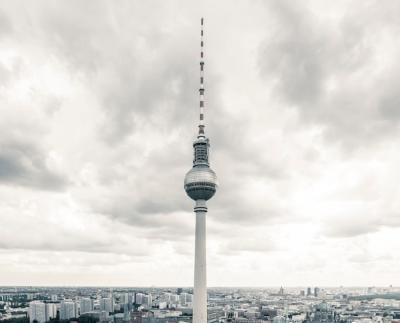 Communications Tower in City Against Cloudy Sky – Download Free Stock Photo