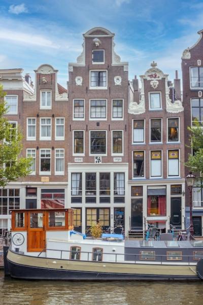 Typical Netherlands Building Facades Along Amsterdam Canal with Houseboat Barge – Free Download