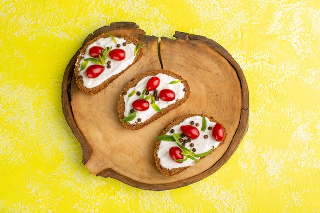 Top View of Bread Toasts with Sour Cream and Dogwoods on Yellow Surface – Free Stock Photo for Download