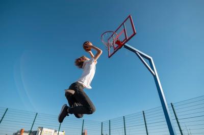 Man Playing Basketball from a Low Angle – Free Download