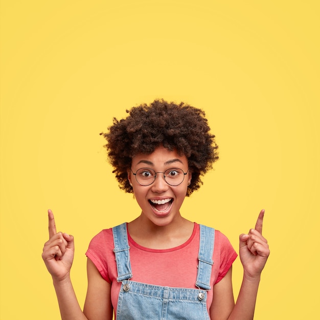 Joyful African American Woman Smiling Against a Yellow Wall – Free Stock Photo for Download