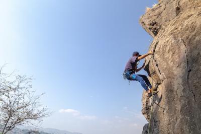 Young Male Climber on a Rocky Cliff Against a Blue Sky – Free Stock Photo, Download for Free