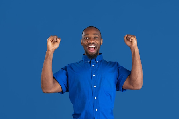 Young Man Posing Against a Blue Studio Wall – Free Download