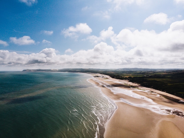 Aerial View of Scenic Beach Shore and Grassy Field under Cloudy Sky – Free Stock Photo, Download Free